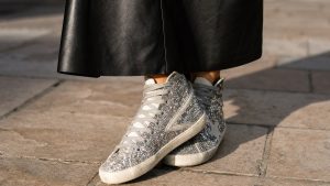 Faustine Bollaert remplace ses baskets blanches par des sneakers montantes à paillettes qu'on verra partout la saison prochaine